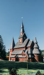 Temple by building against clear sky