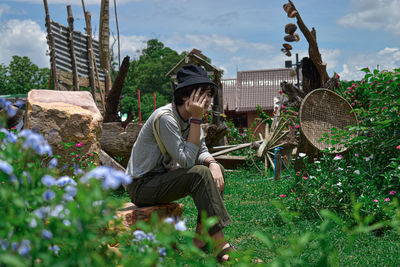 A man sitting on a rock among nature.