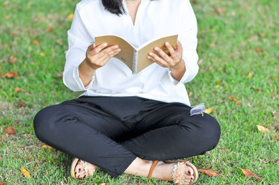 Rear view of woman sitting on field