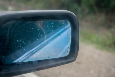 Close-up of raindrops on side-view mirror