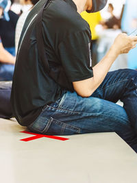 Midsection of man using mobile phone