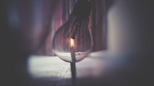 Close-up of light bulb hanging against wall