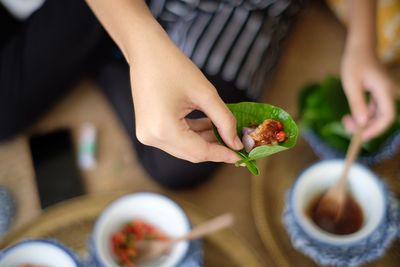 Midsection of person holding fruit on table