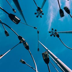 Low angle view of shoes hanging against blue sky