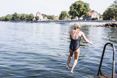 Girl jumping into sea