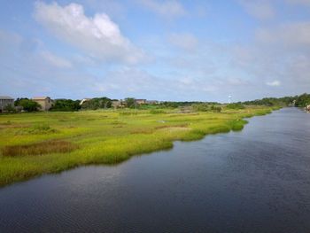 Scenic view of river against cloudy sky