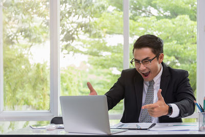 Young man using mobile phone at table