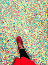 Low section of woman standing on multi colored confetti