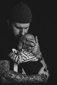 Father and son against black background