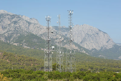 Electricity pylon on land against sky