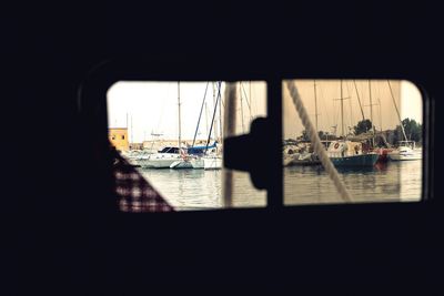 Sailboats in city seen through window