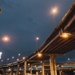 Low angle view of illuminated bridge against sky at night