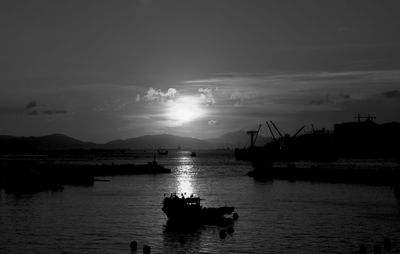 Silhouette boat in sea against sky during sunset