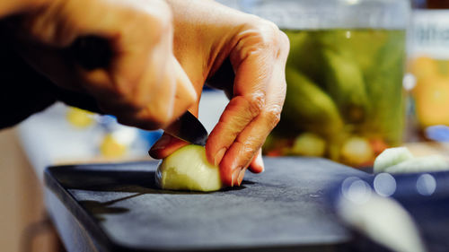 Cropped hands chopping onion