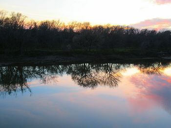 Reflection of trees in lake against sky during sunset