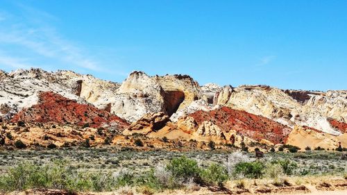 Rocks on land against blue sky