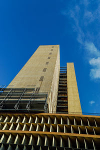 Low angle view of office building against blue sky