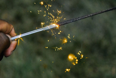 Cropped image of person holding sparkler