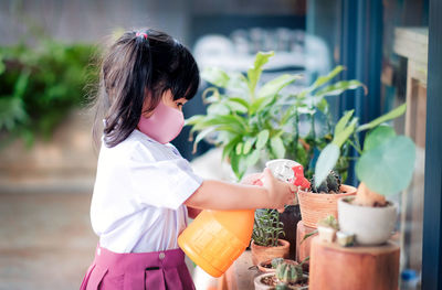 Side view of woman with potted plants