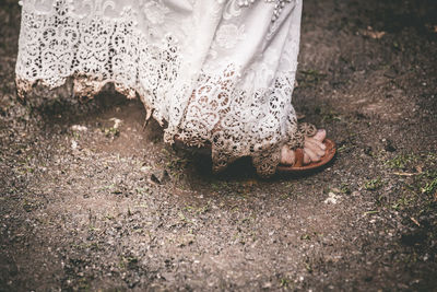 Low section of woman standing on dirt field