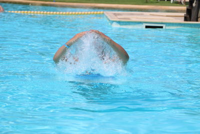 Person gesturing in swimming in pool