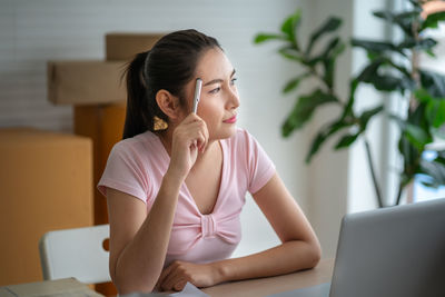 Thoughtful woman looking away while sitting at office