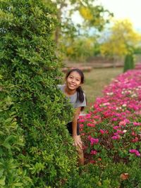 Portrait of smiling woman standing by plants