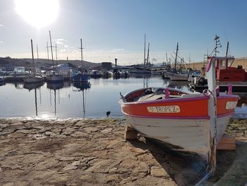 Boats moored at harbor against sky