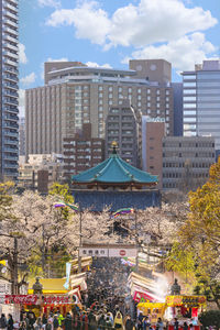 Buildings in city against cloudy sky