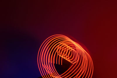 Illuminated light trails against sky at night