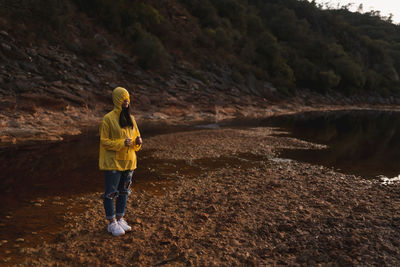 Rear view of woman standing on shore