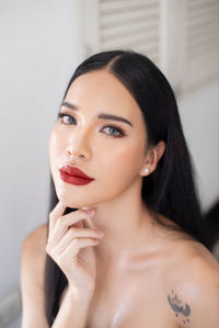 Close-up of young woman against wall