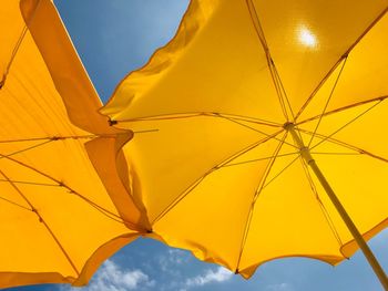 Low angle view of yellow umbrella against sky
