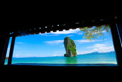 Scenic view of sea against blue sky seen through window