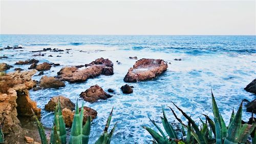 Rocks on sea shore against sky