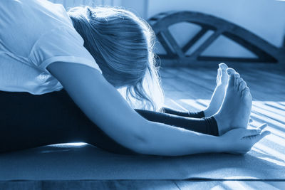 Young woman sitting on bed at home