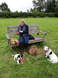 Portrait of mature woman with dogs on field