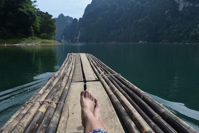 Low section of person relaxing by lake