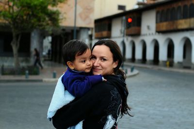 Portrait of a smiling young woman on street in city