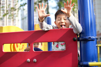 Boy sticking out tongue while playing at playground