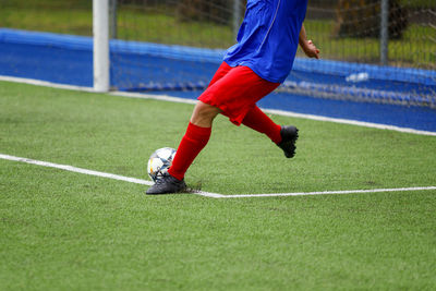 Low section of player playing soccer on field