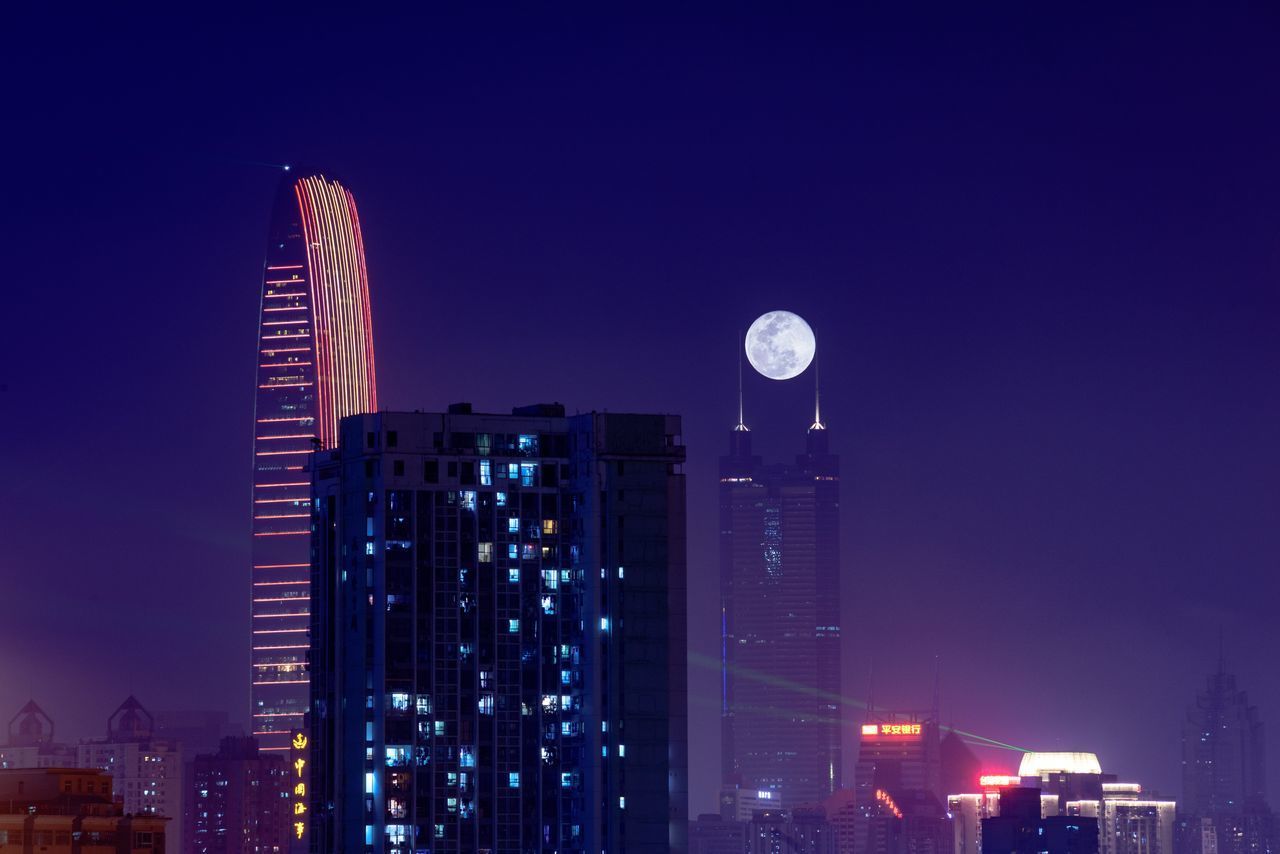 LOW ANGLE VIEW OF ILLUMINATED BUILDINGS AGAINST SKY