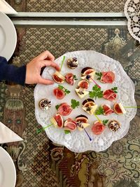 High angle view of woman holding fruit on table