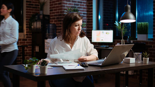 Businesswoman using laptop on table