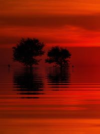 Silhouette tree by lake against romantic sky at sunset