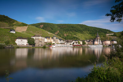 Scenic view of lake by buildings against sky