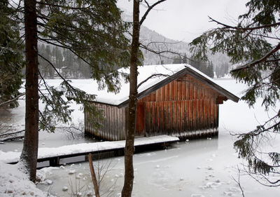 Cabin by a frozen lake in winter.