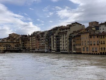 Buildings in city against cloudy sky