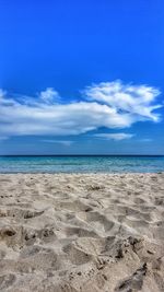 Scenic view of beach against blue sky