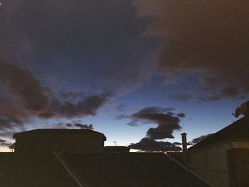 Low angle view of silhouette house against sky at night